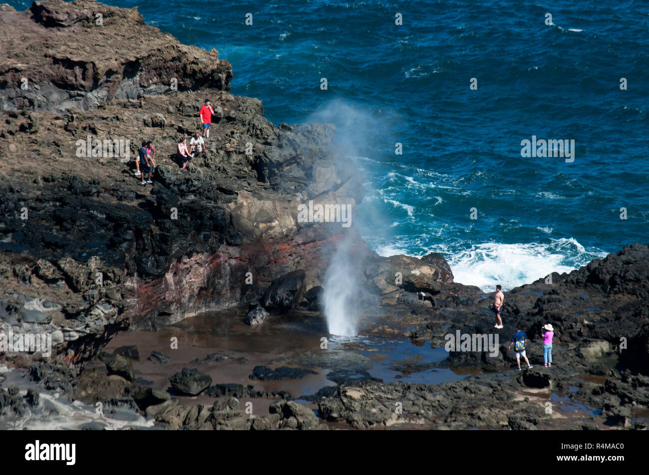 A big blow hole on the north-eastern shore of Maui is a popular attraction for visitors. Stock Photo