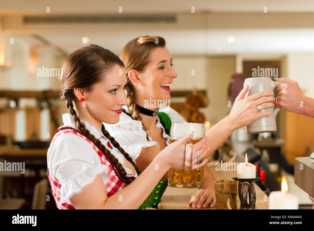 Two young women in traditional Bavarian Tracht in restaurant or pub Stock Photo