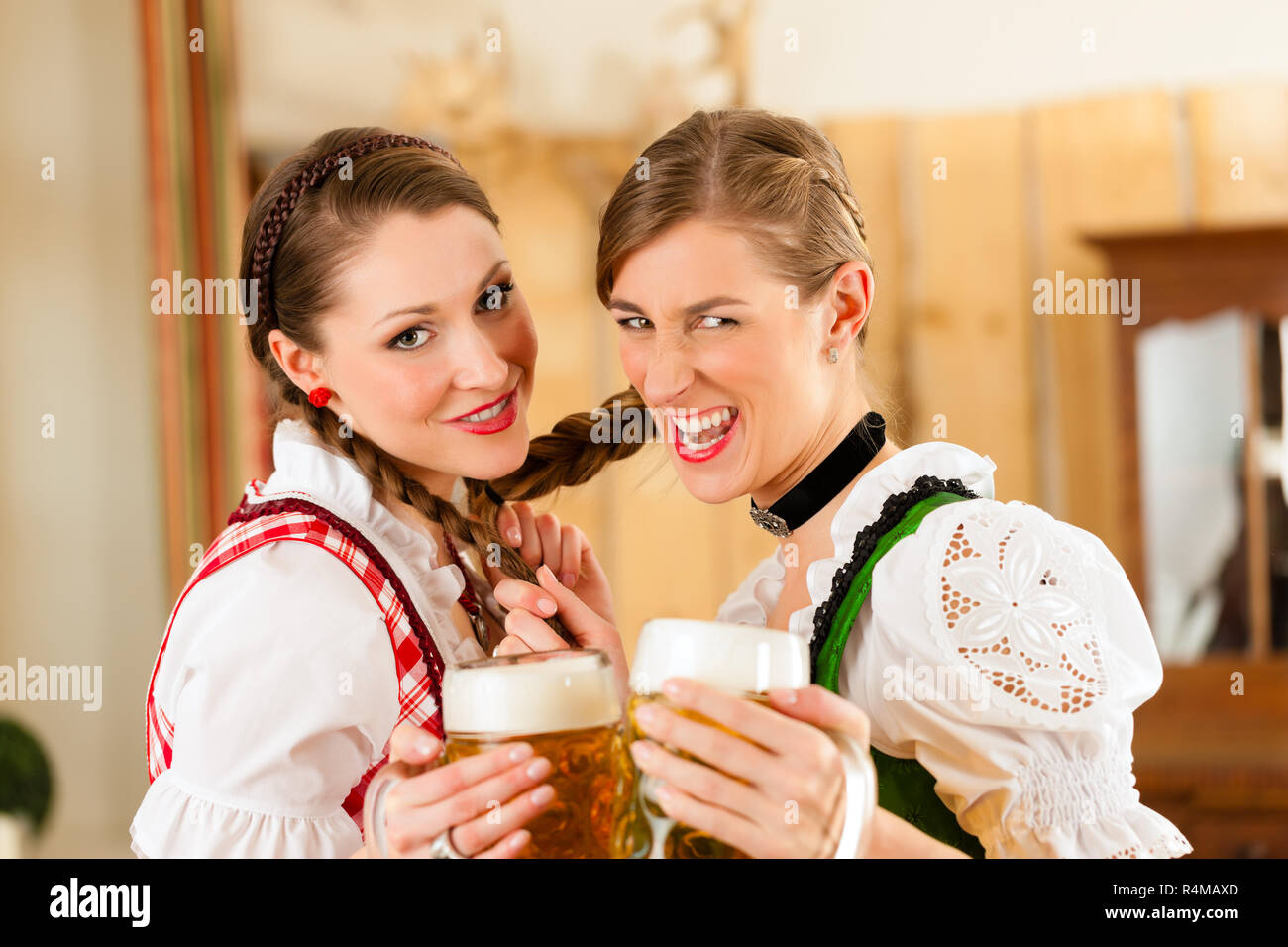 Two young women in traditional Bavarian Tracht in restaurant or pub Stock Photo
