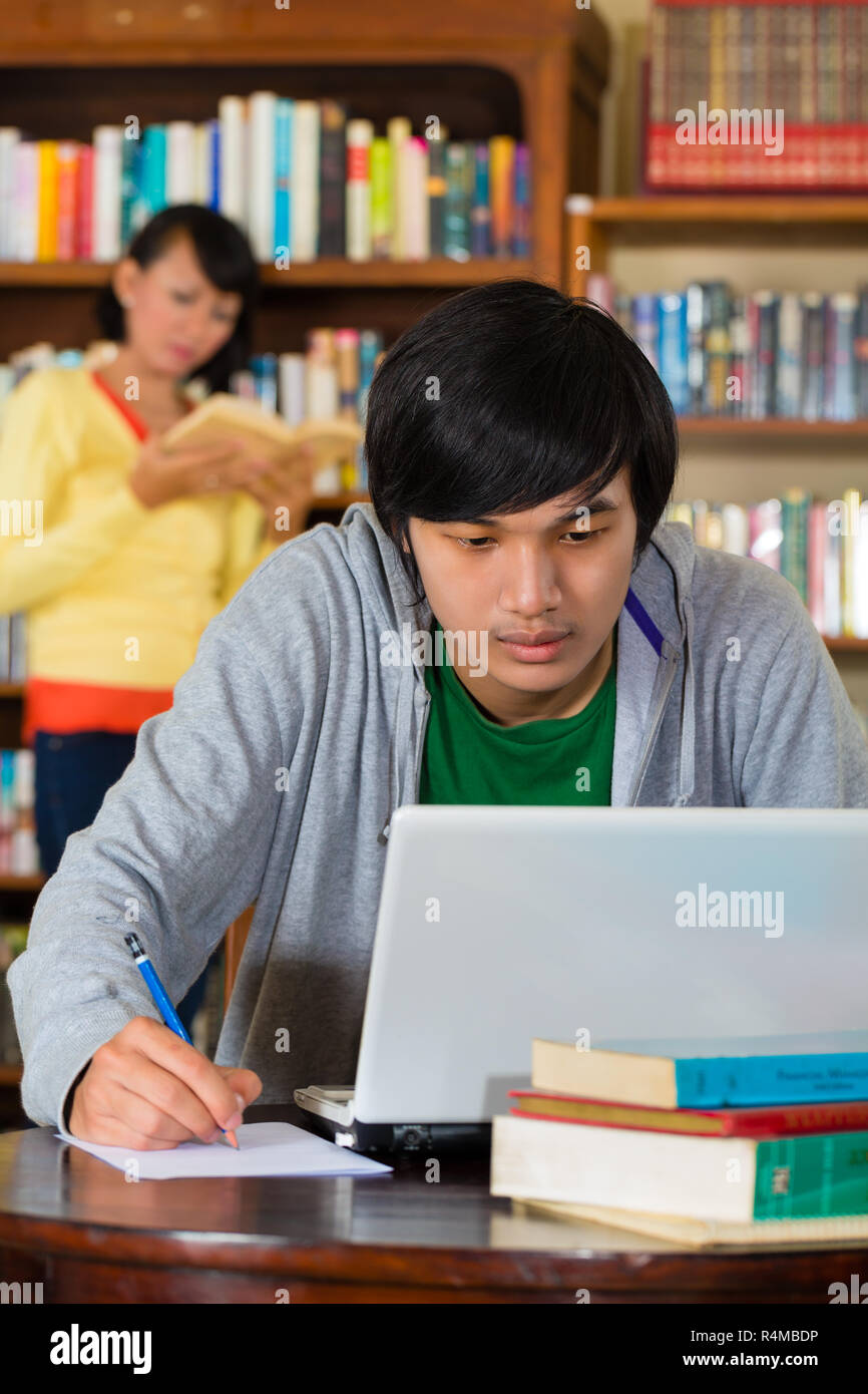 Man in library with laptop Stock Photo Alamy