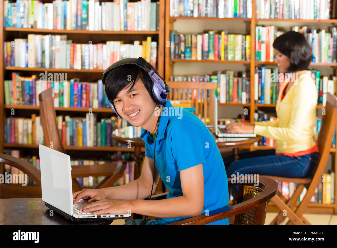 Student in library with laptop Stock Photo - Alamy