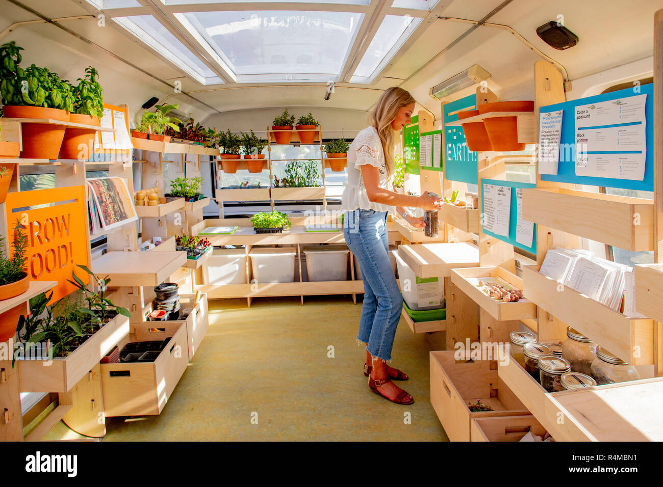 Kathryn Riordan organizes exhibits on the Ecology Bus second story Mobile Greenhouse. Stock Photo