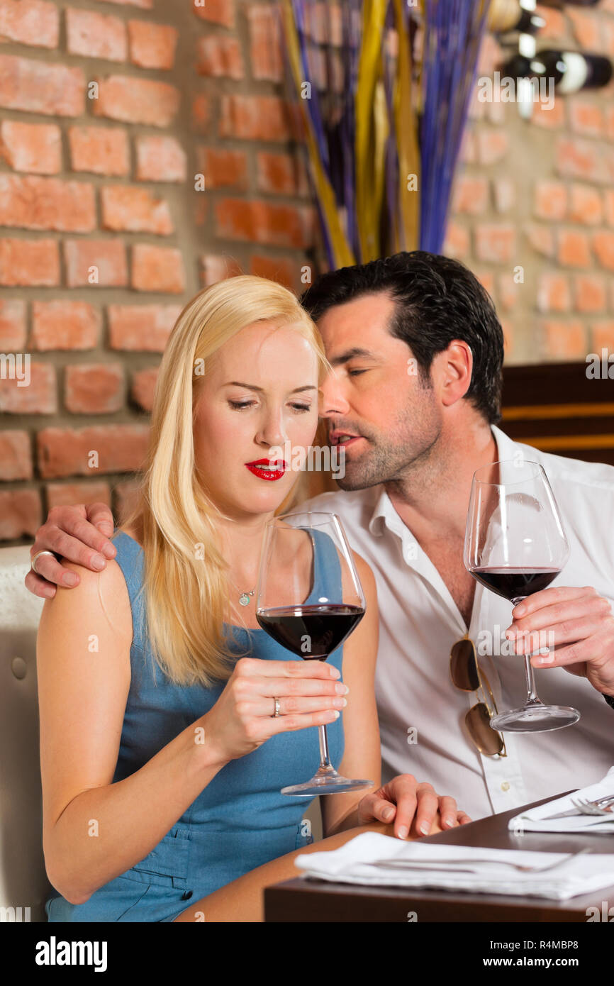 Attractive couple drinking red wine in restaurant or bar Stock Photo