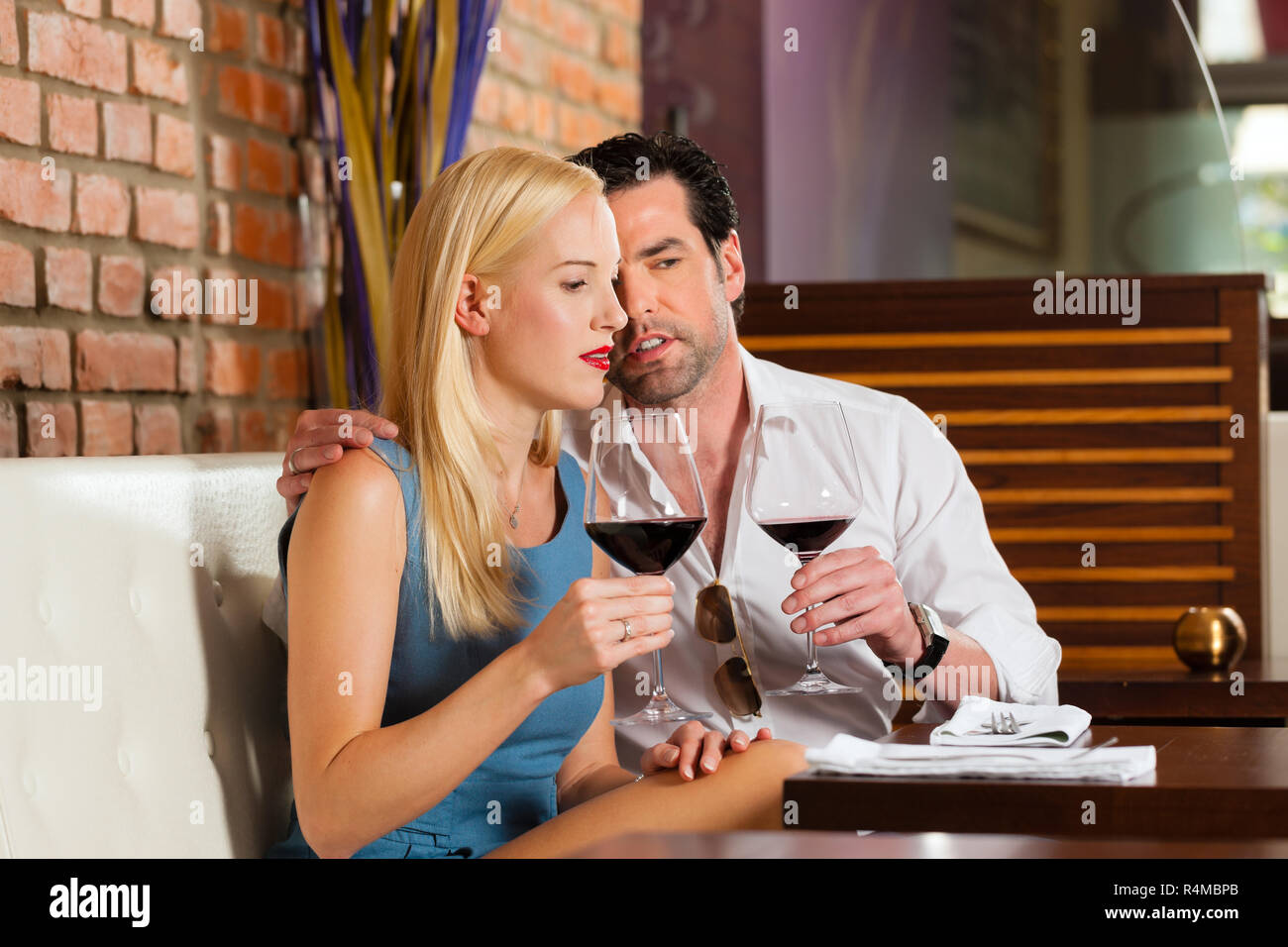 Attractive couple drinking red wine in restaurant or bar Stock Photo