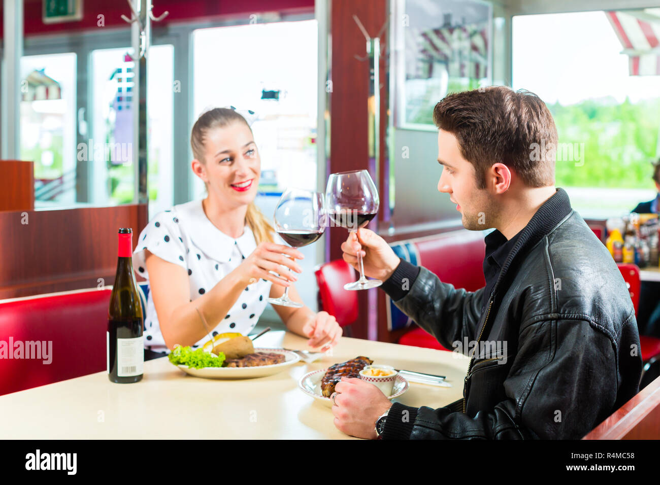 Friends or couple eating and drinking in fast food diner Stock Photo Alamy