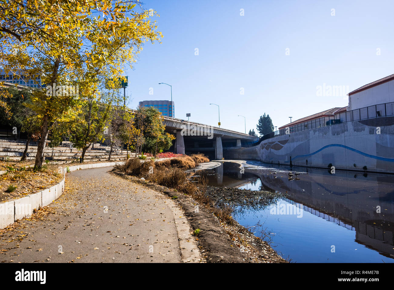 Paved walking path following the shoreline of Guadalupe river close to ...