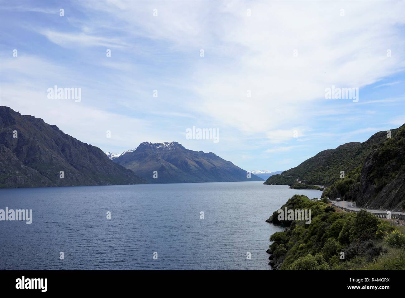 Road at the edge of the lake, surrounded by mountains.New Zealand South Island Stock Photo