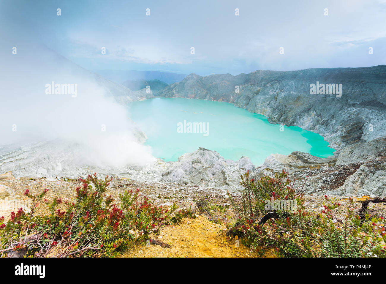 Sulfuric cloud around turquoise lake out from Ijen mountains crater Banyuwangi, Indonesia Stock Photo