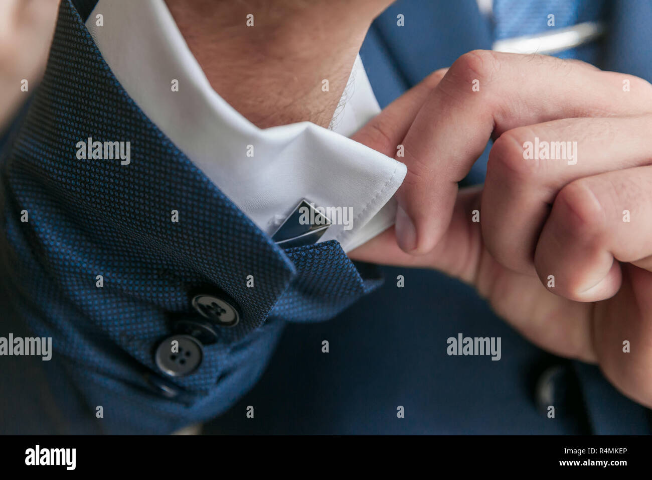 Close-up of a man in a tux fixing his cufflink. groom bow tie cufflinks Stock Photo