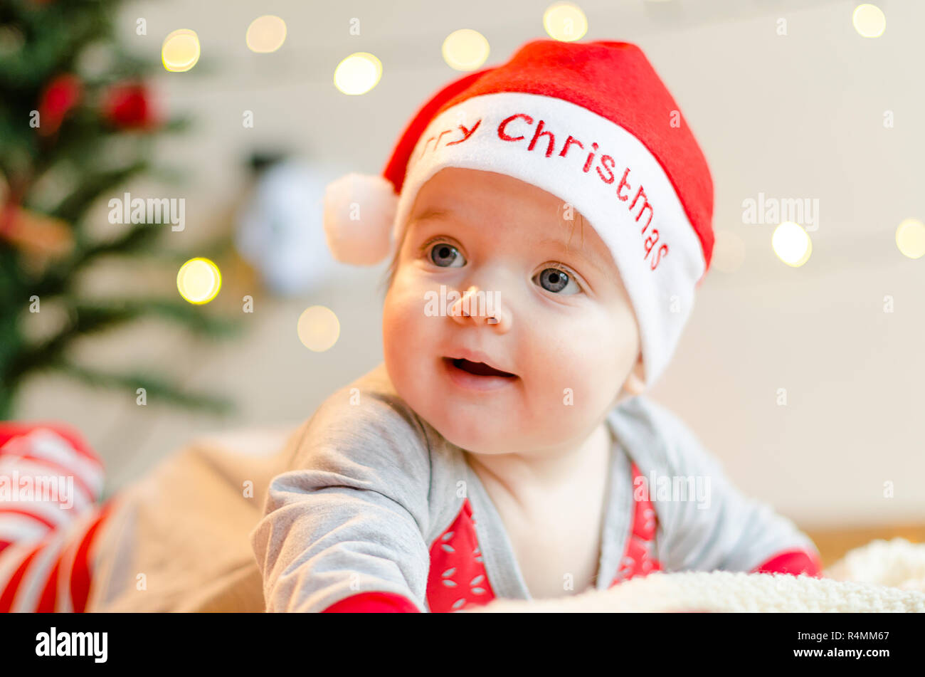 Happy Christmas baby girl in a present box around Christmas tree and decorations Stock Photo