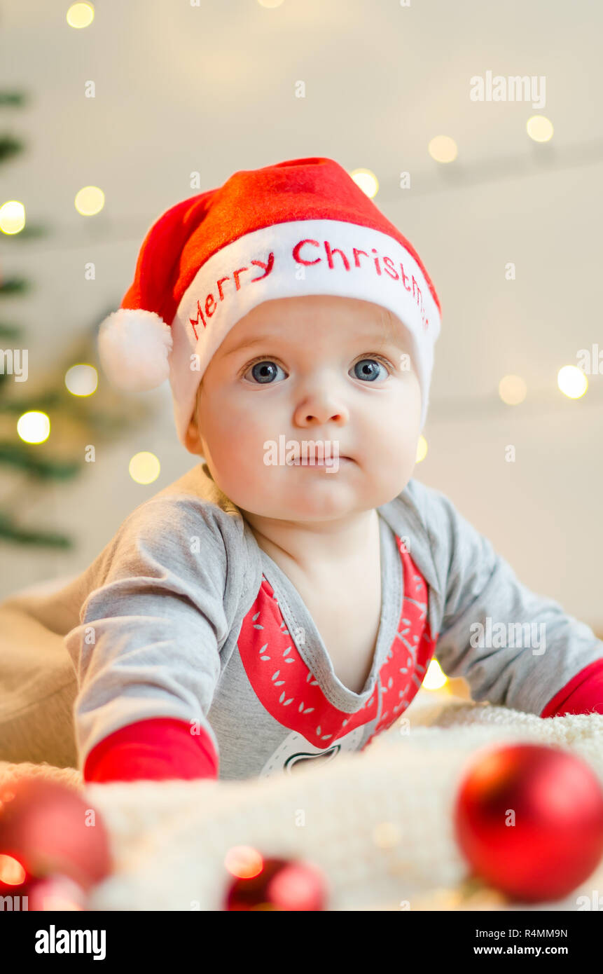 Happy Christmas baby girl in a present box around Christmas tree and decorations Stock Photo