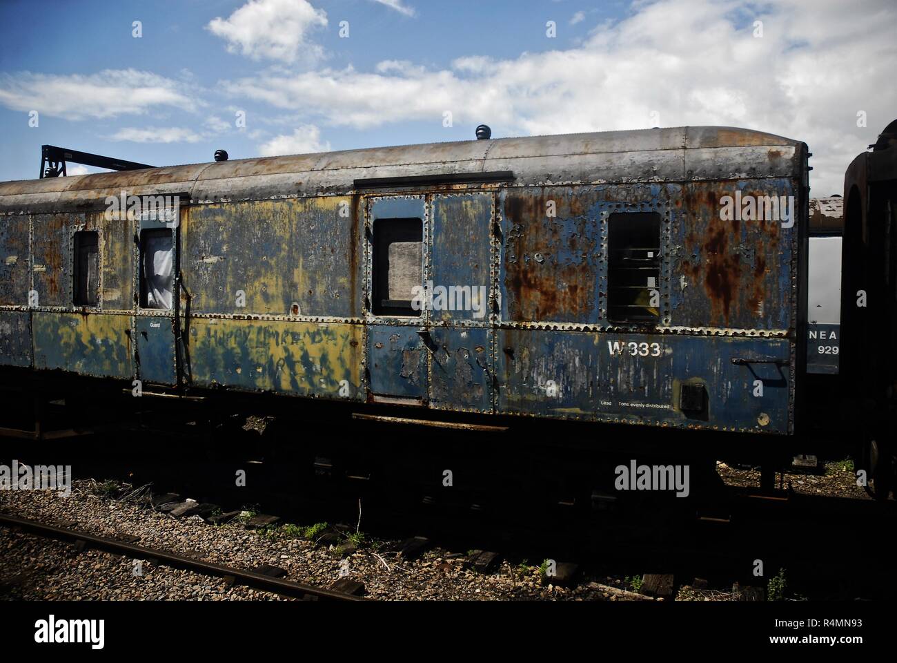 An unrestored heavily distressed looking railway carriage stored in ...