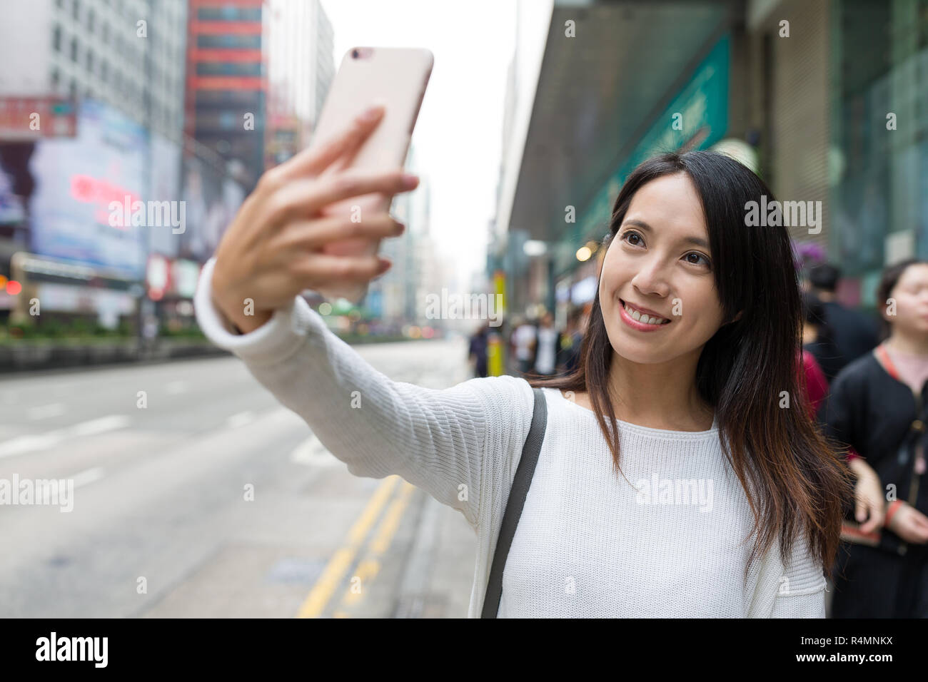 Woman taking selfie with cellphone in Mong Kok city in Hong Kong Stock ...