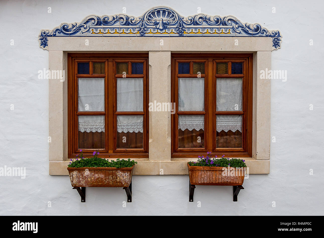 Two Beautiful Windows With a Rectangular Plants Vase Underneath Stock Photo