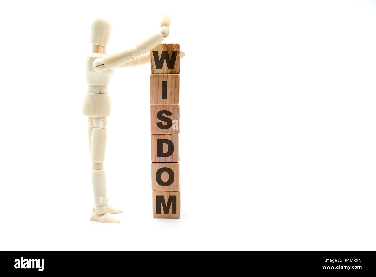 Wooden figure as businessman building Wisdom as tower of wood cubes, isolated on white background, minimalist concept Stock Photo