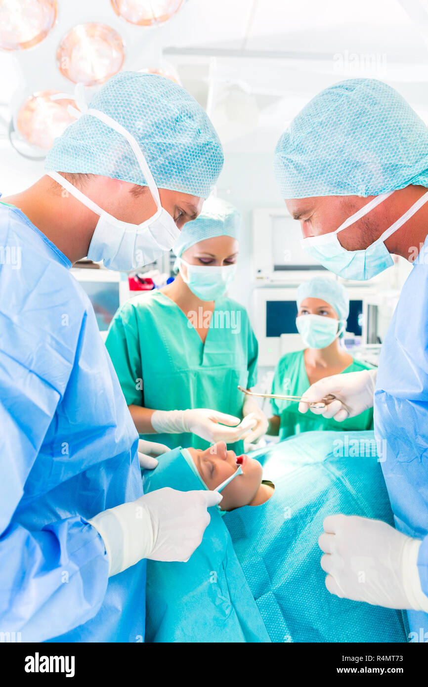 Surgeons operating in operation theater room Stock Photo