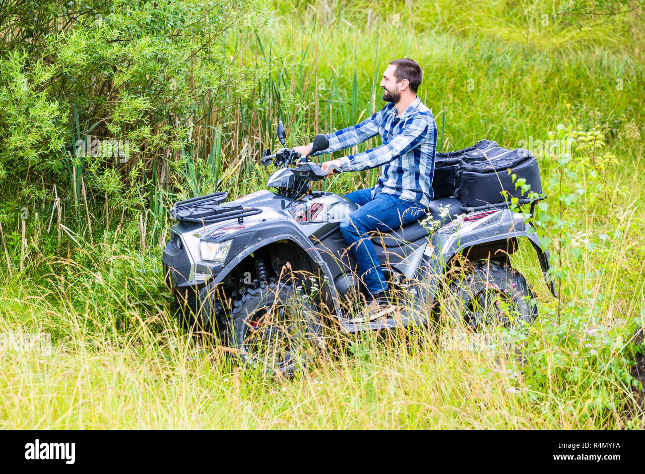 Man driving off-road with quad bike or ATV Stock Photo - Alamy