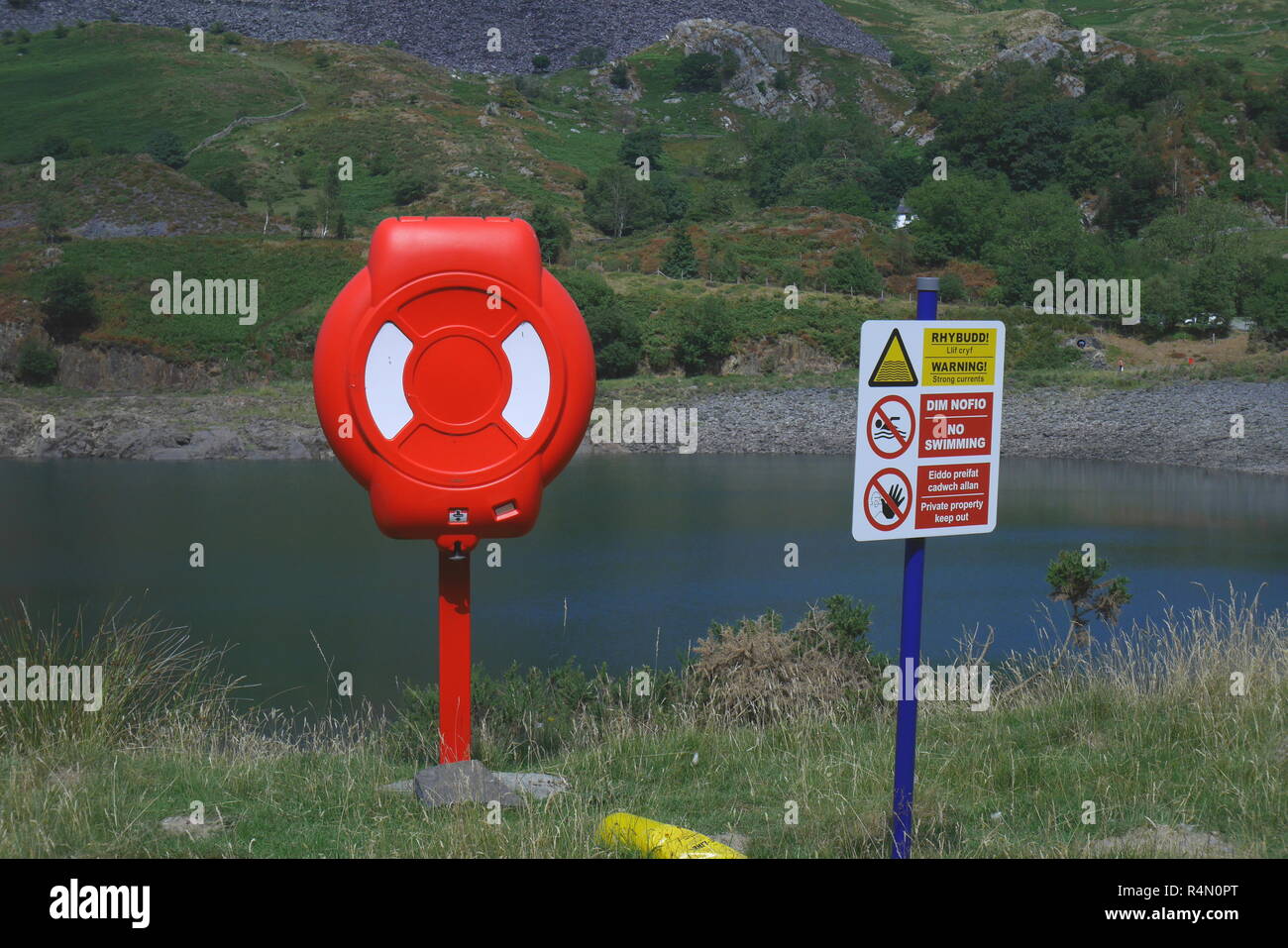 Life ring and warning sign next to a lake in Snowdonia, North Wales, Inited Kingdom Stock Photo