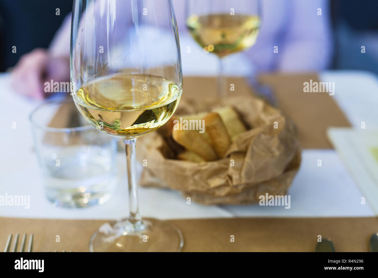 glass of white wine on a table in a restaurant Stock Photo - Alamy