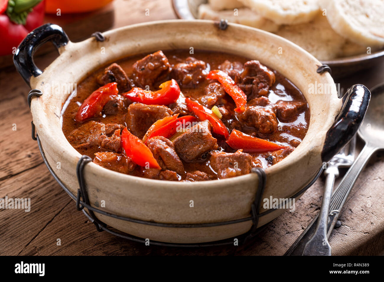 A bowl of delicious authentic Hungarian goulash with bread dumplings and red pepper garnish. Stock Photo