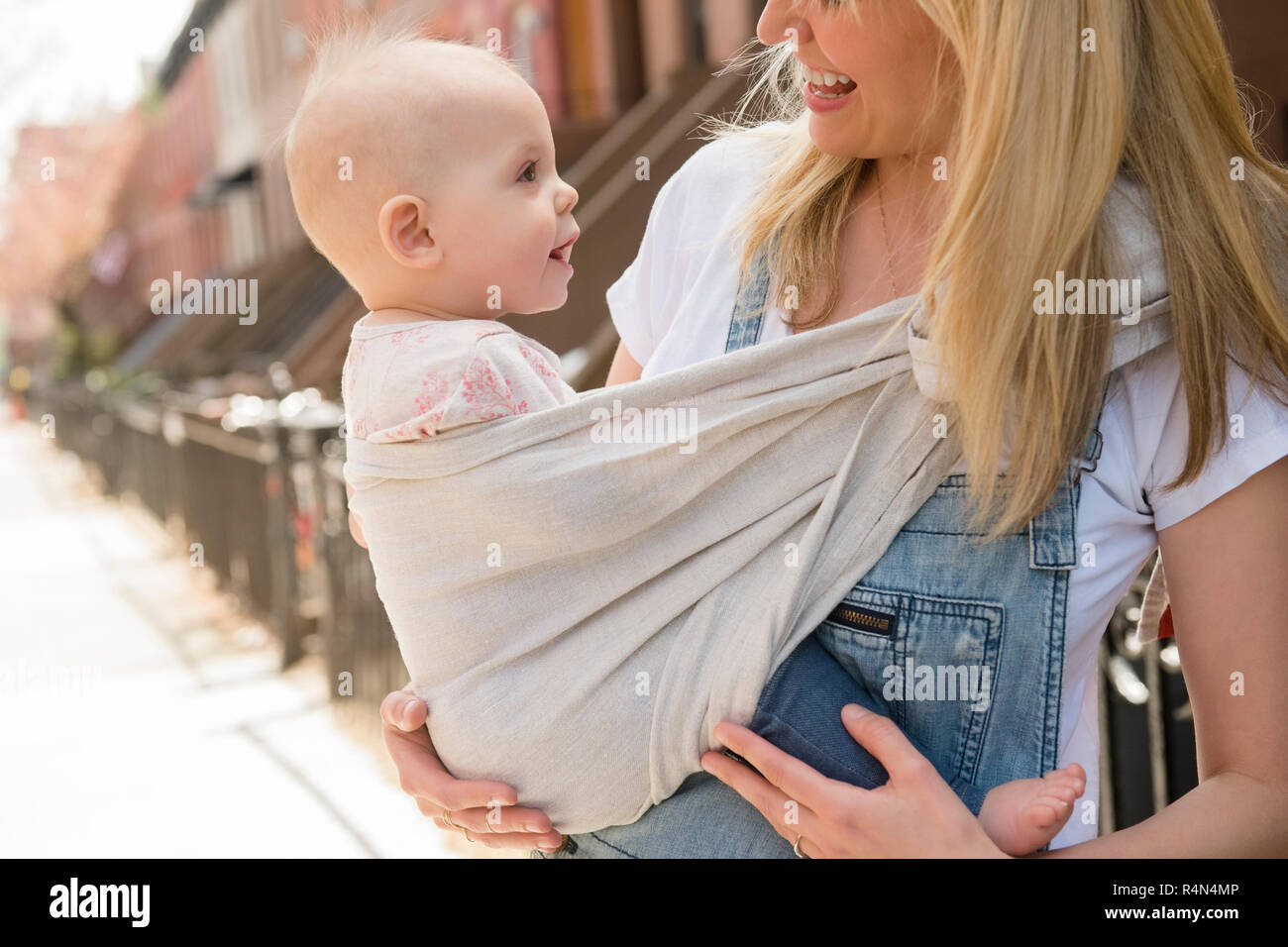 Mother carrying her daughter in baby carrier Stock Photo Alamy