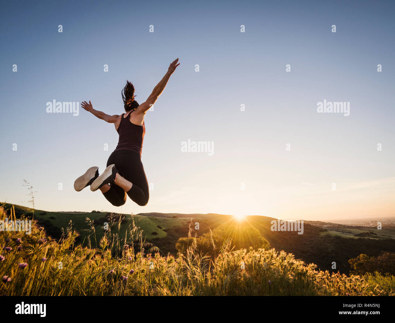 Woman jumping at sunset Stock Photo