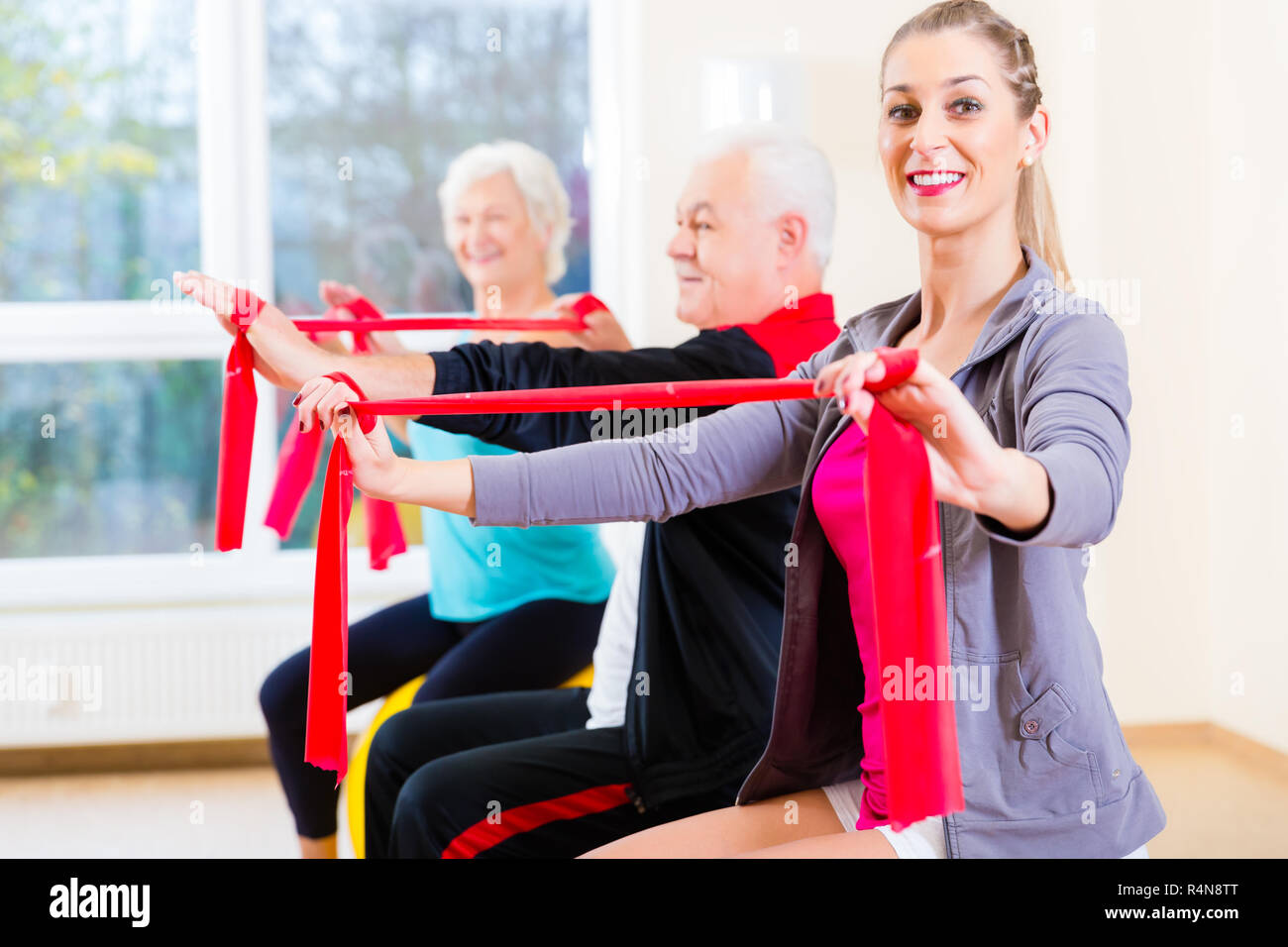 People at gym exercise with stretch band Stock Photo