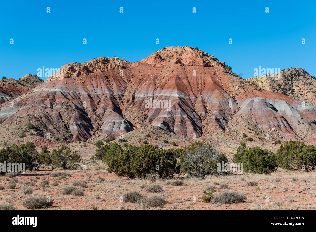 Colorful mountain peak under a perfect blue sky in the high desert near Abiquiu, New Mexico in the American Southwest Stock Photo