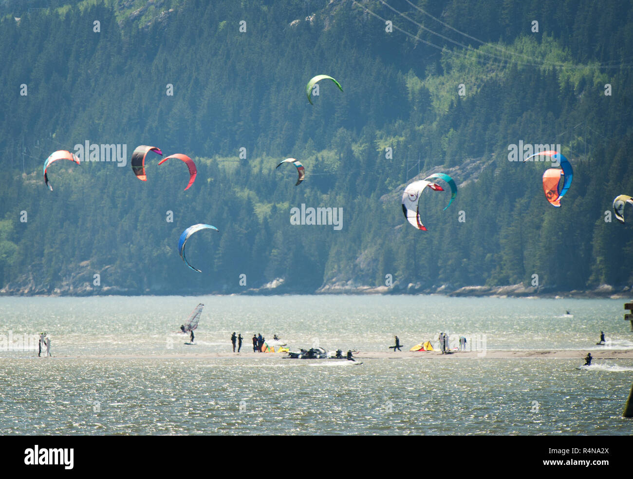 Kite boarders stand on an sand bar near Squamish Terminals.  An extra low tide exposed the normally submerged sand bar.  Saturday, May 27, 2017.  Phot Stock Photo