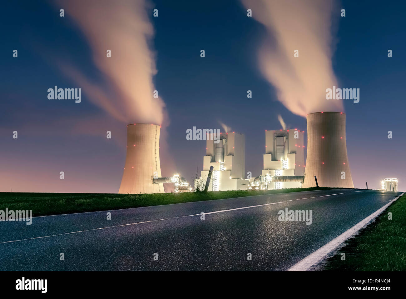night shot of illuminated lignite power plant with cooling towers Stock Photo