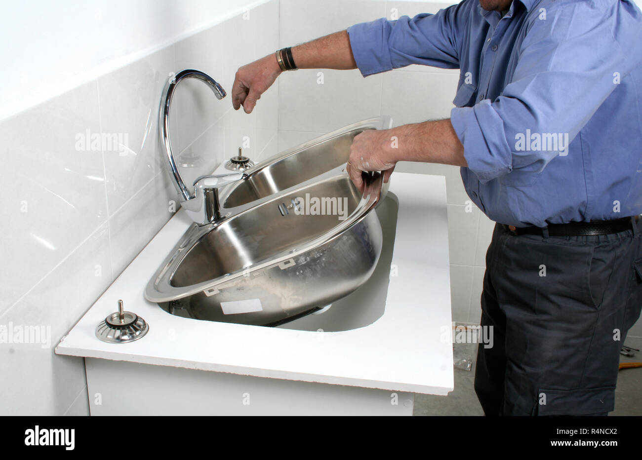 Construction Worker Installing A Stainless Steel Kitchen Sink