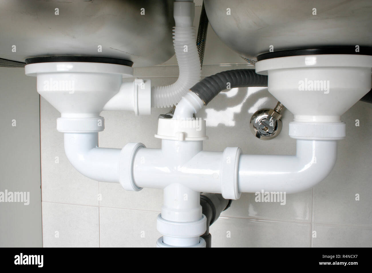 View of the drain pipes of a kitchen sink with dishwasher connection Stock  Photo - Alamy