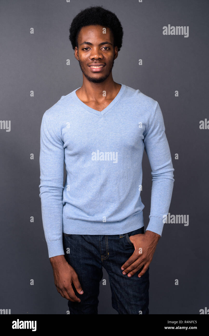 Young handsome African man against gray background Stock Photo