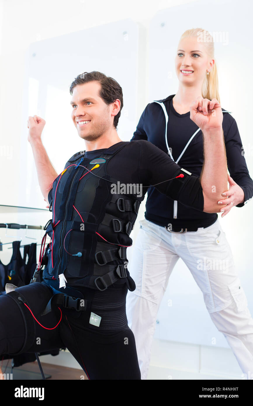 Man having ems training with personal trainer Stock Photo - Alamy