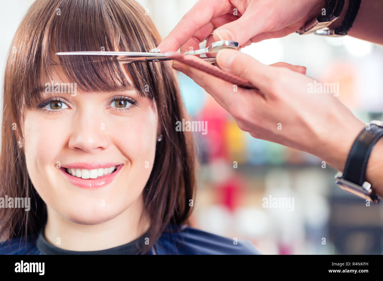 Hairdresser cutting woman bangs hair in shop Stock Photo Alamy