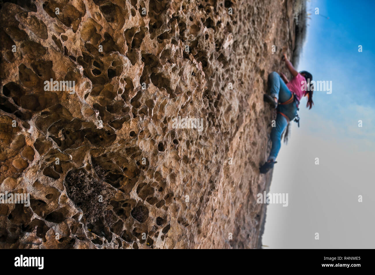 View from below of woman rock climbing up cliff, Â Suesca, Â Almeidas Province, Â Colombia Stock Photo