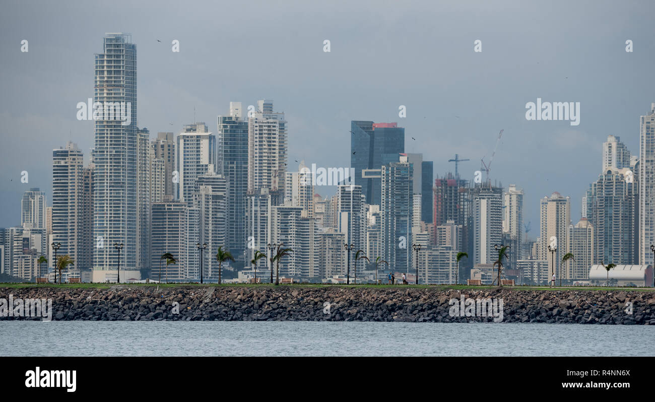 Hot humid day in Panama city as another rainstorm brews quickly over city skyline.  Tall buildings shimmer in heatwaves rising in humid air. Stock Photo
