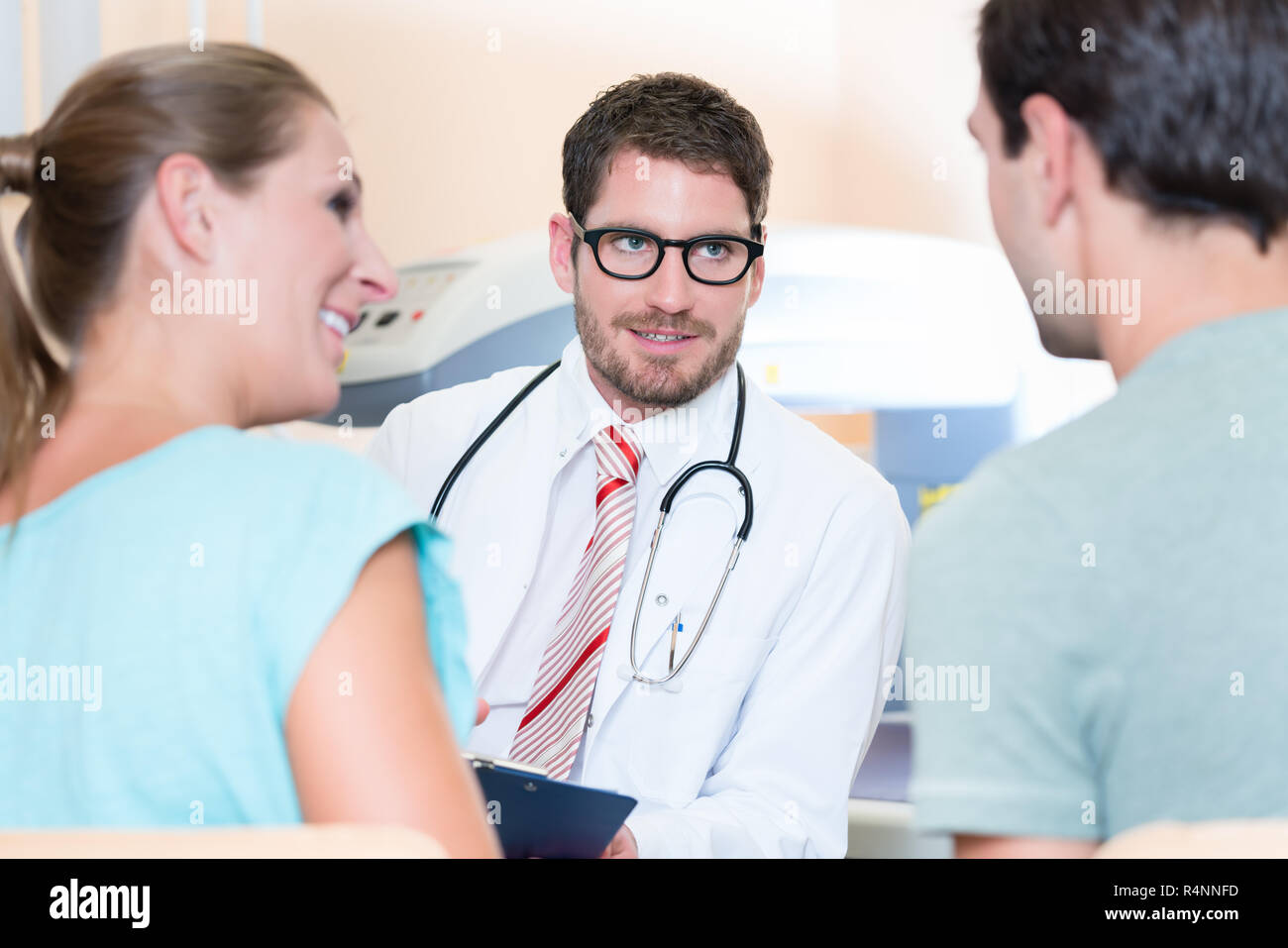 Pregnant woman and her partner seeing physician Stock Photo