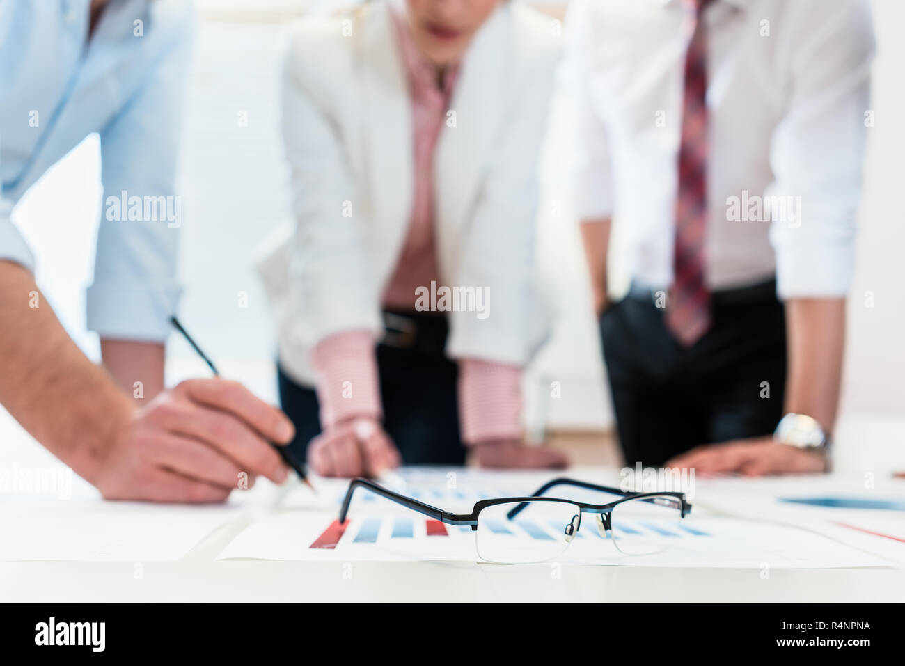 Business people analyzing data - glasses on graph Stock Photo