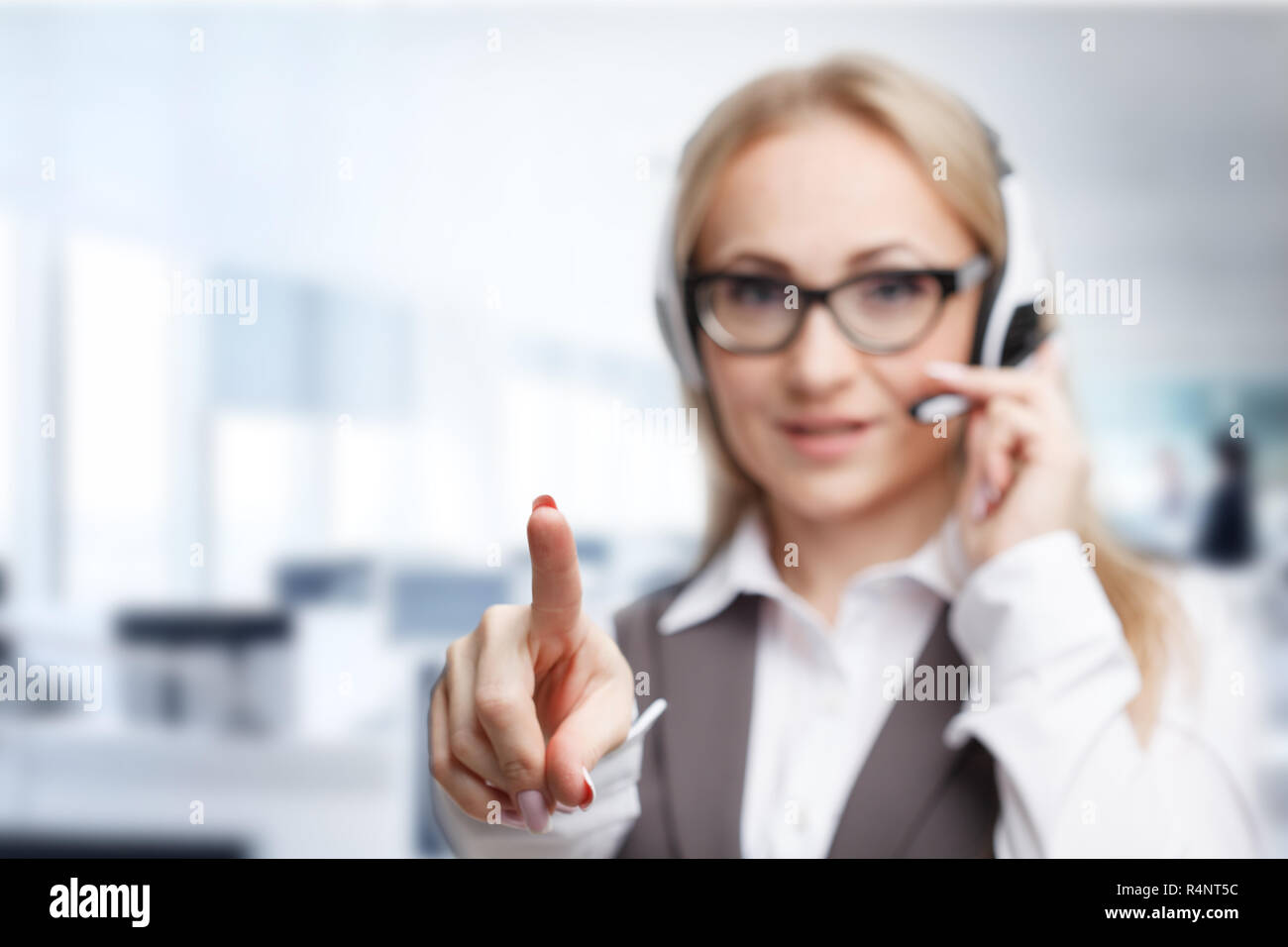 Three call center service operators at work. Portrait of smiling pretty female helpdesk employee with headset at workplace. Stock Photo