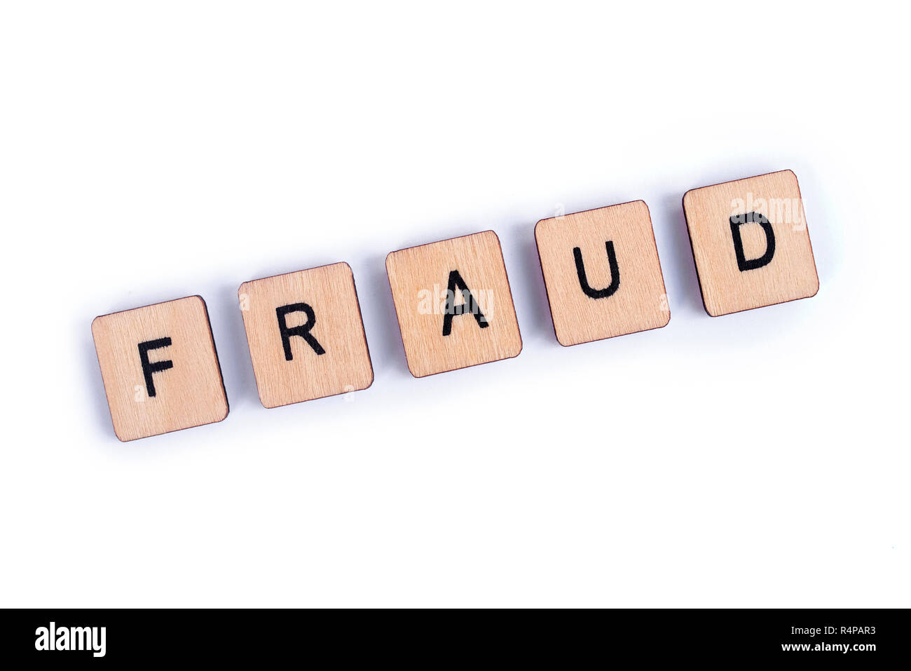 The word FRAUD, spelt with wooden tile letters. Stock Photo