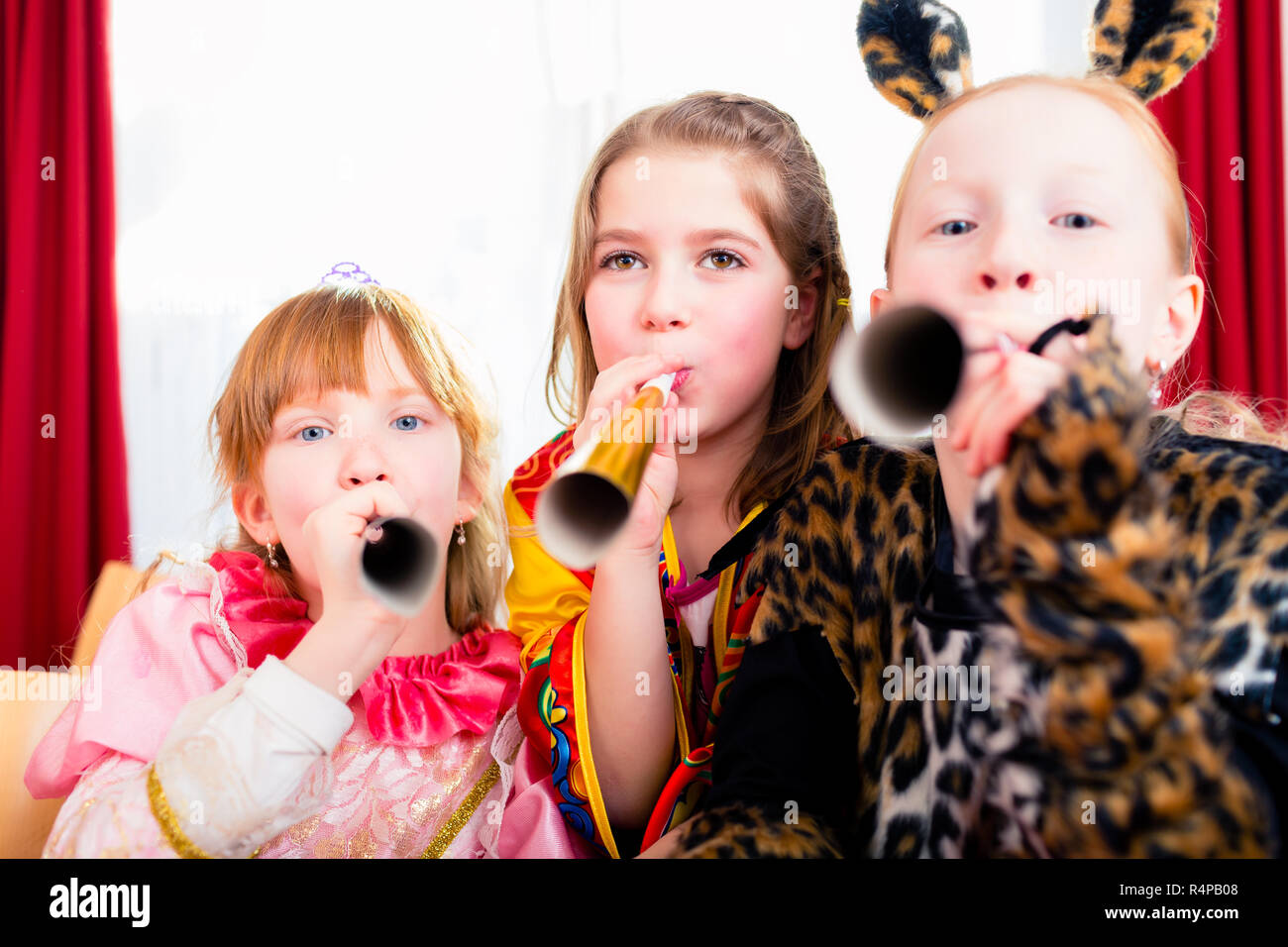Kids with noisemakers making noise on party Stock Photo Alamy