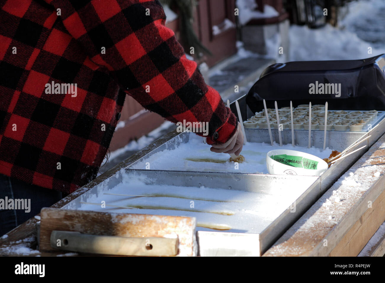 A French Canadian pouring Maple Taffy in Old Quebec, Canada Stock Photo