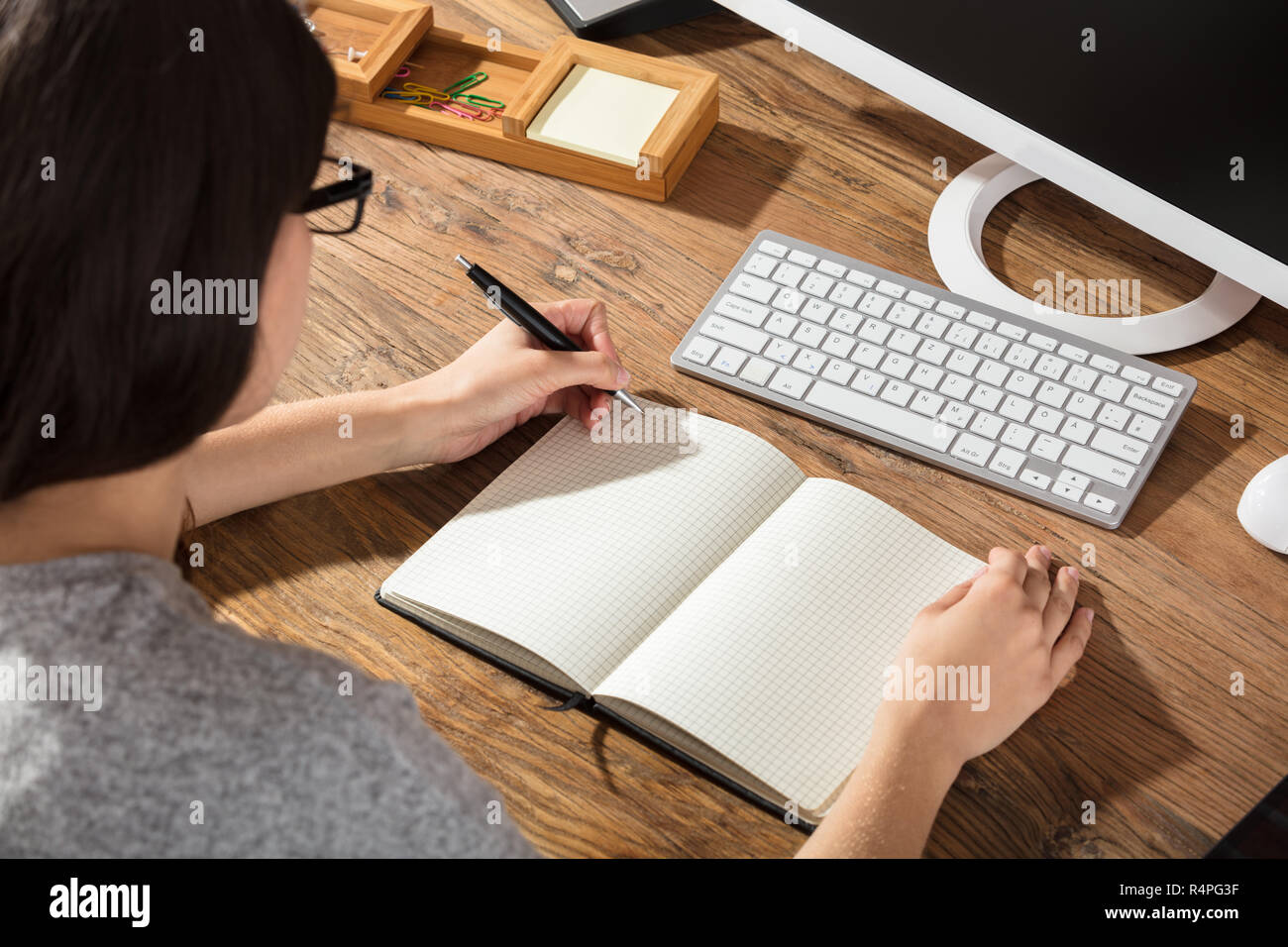 Woman Writing On Checker Note Book Stock Photo