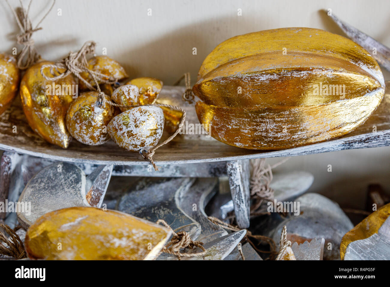 Wooden tropical style Christmas decoration - golden cocoa bean, mushrooms and mangoes at souvenir shop in Bali, Indonesia Stock Photo