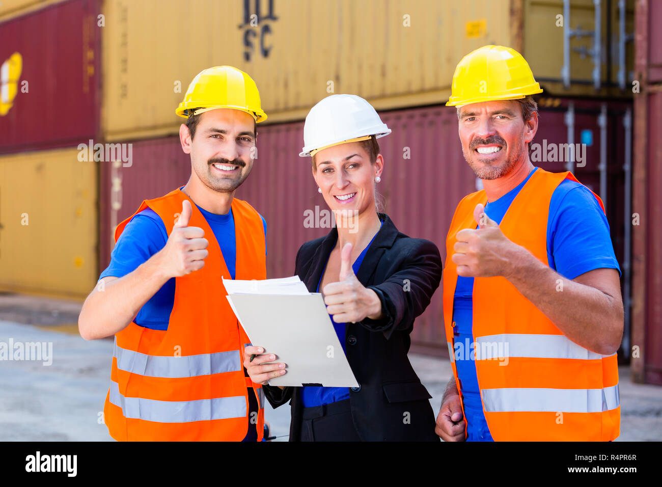 Shipping company workers in front of containers Stock Photo