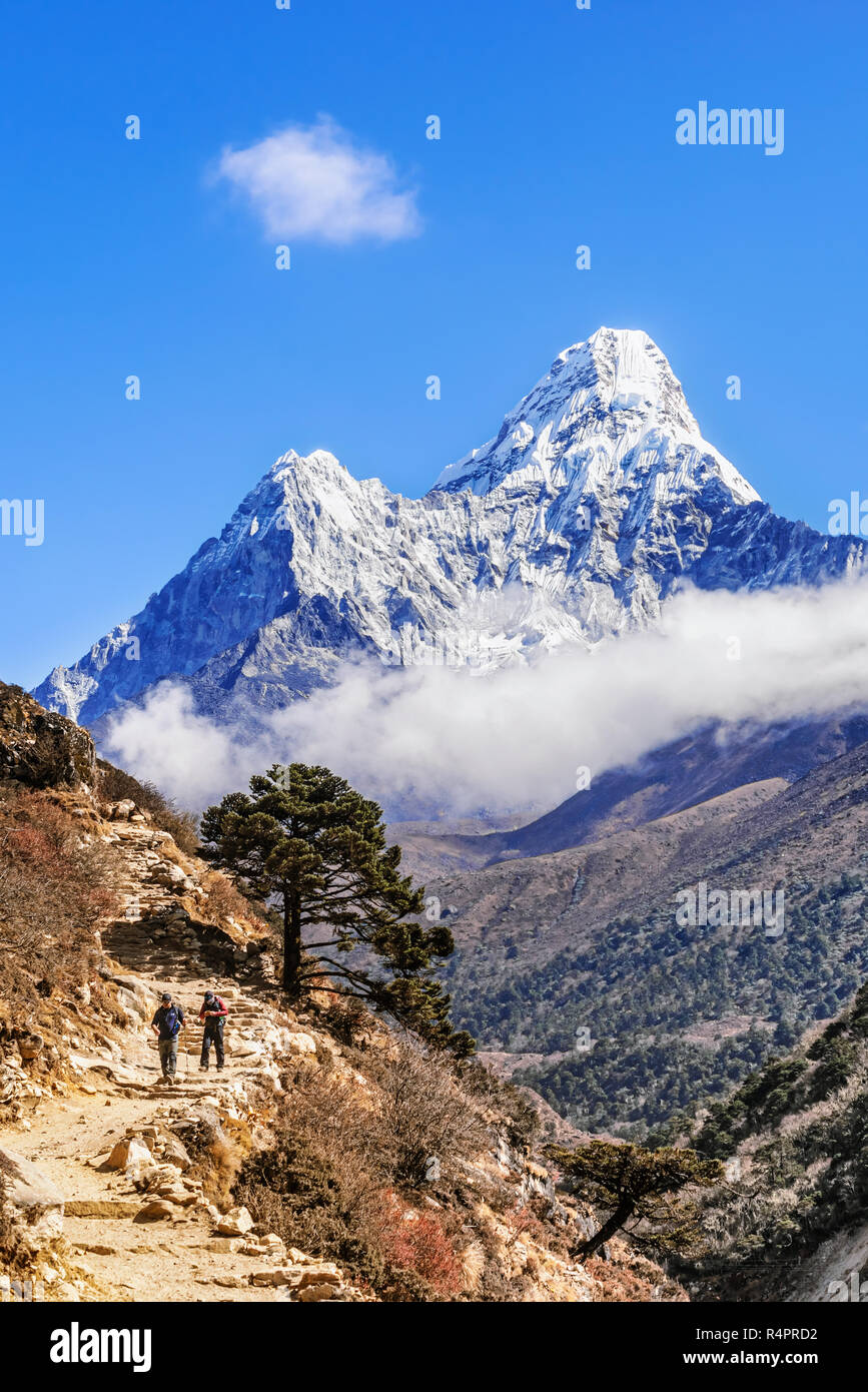 Tengboche, Nepal - Nov 3, 2018: People hiking on the trek to Everest Base camp from Tengboche, majestic Ama Dablam peak at the background. Stock Photo