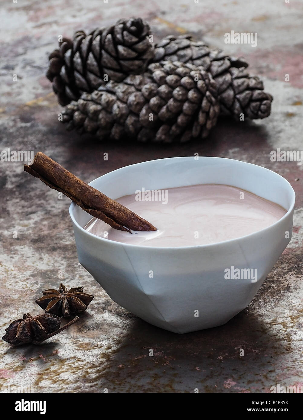 Homemade chai tea latte in a white porcelain bowl with cinnamon stick. Stock Photo