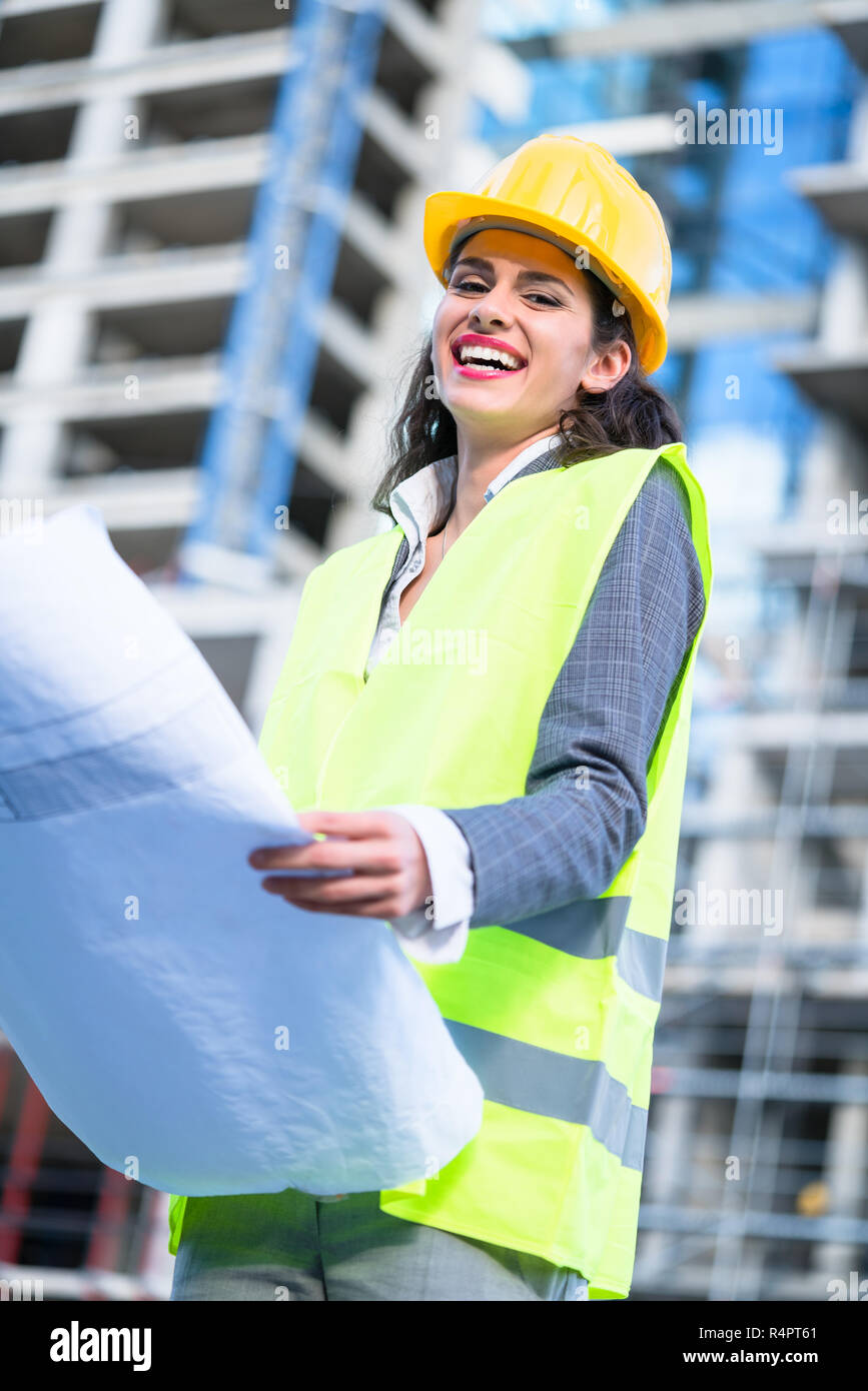Female civil engineer studying drafts visiting construction site Stock Photo