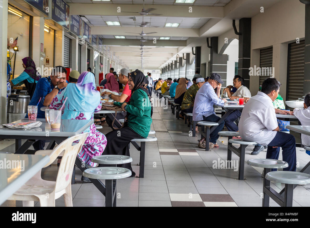 Diners Having Lunch, Individual Food Vendors on Left.  Ipoh, Malaysia. Stock Photo